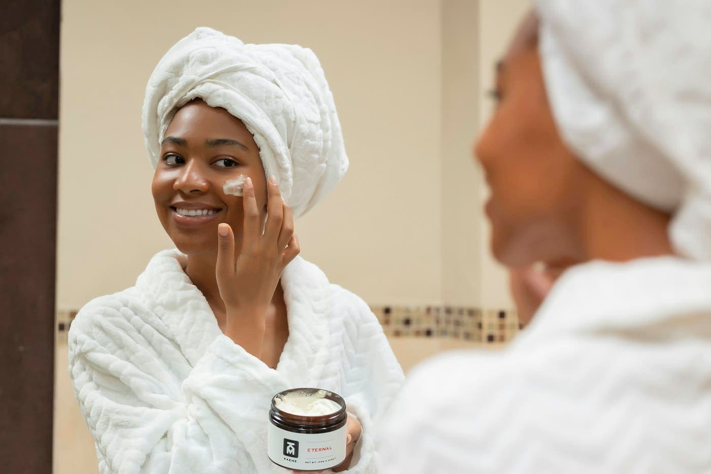 A smiling woman applying face cream