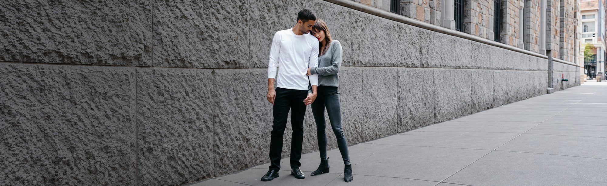 Two people in Mott & Bow denim and tees on a city street